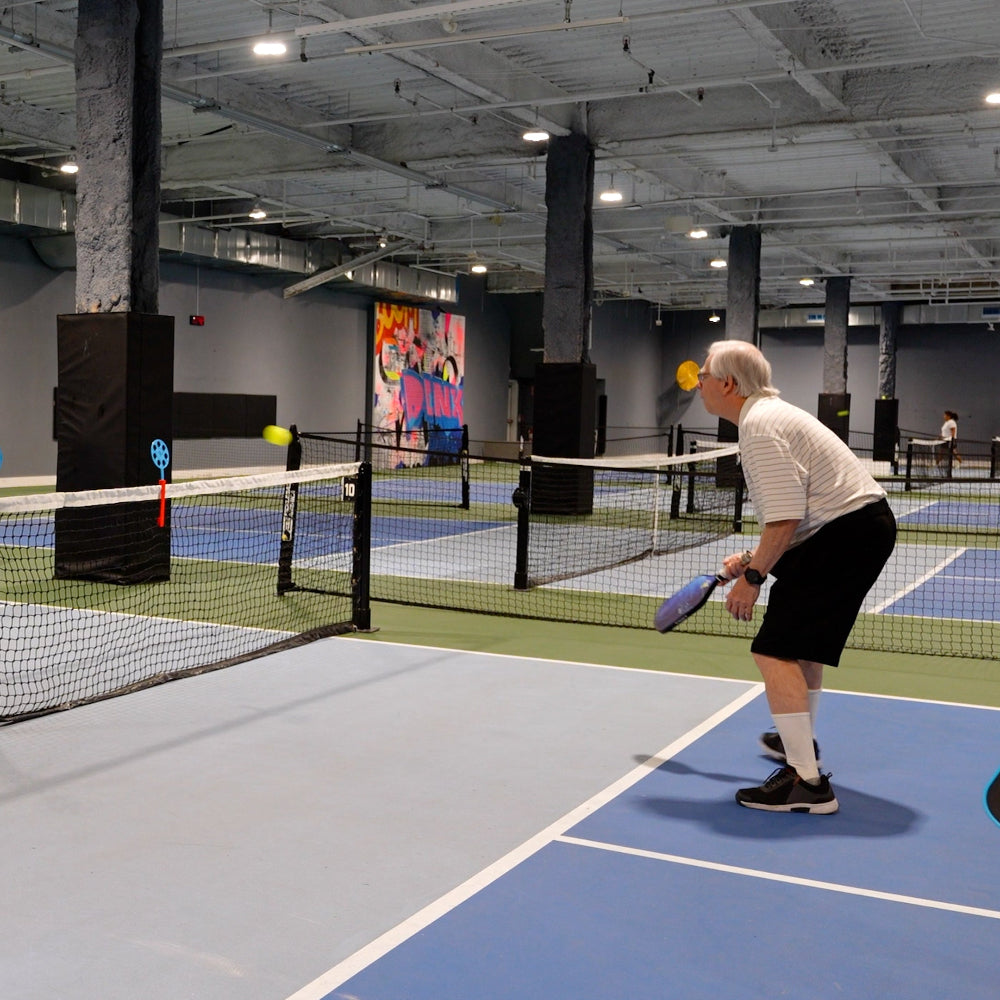 older pickleball player trains using a training aid from truespin