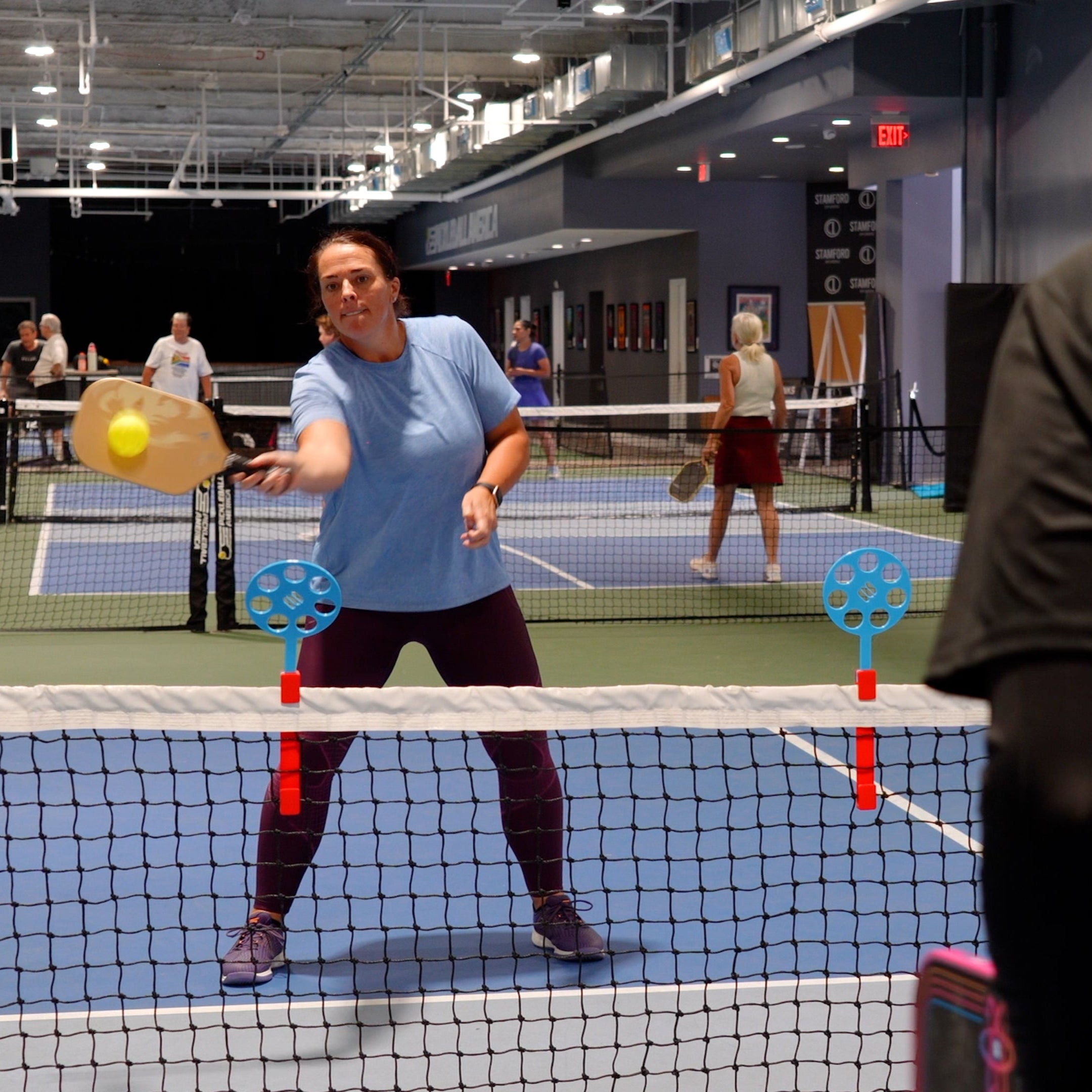woman uses pickleball training aid to dink