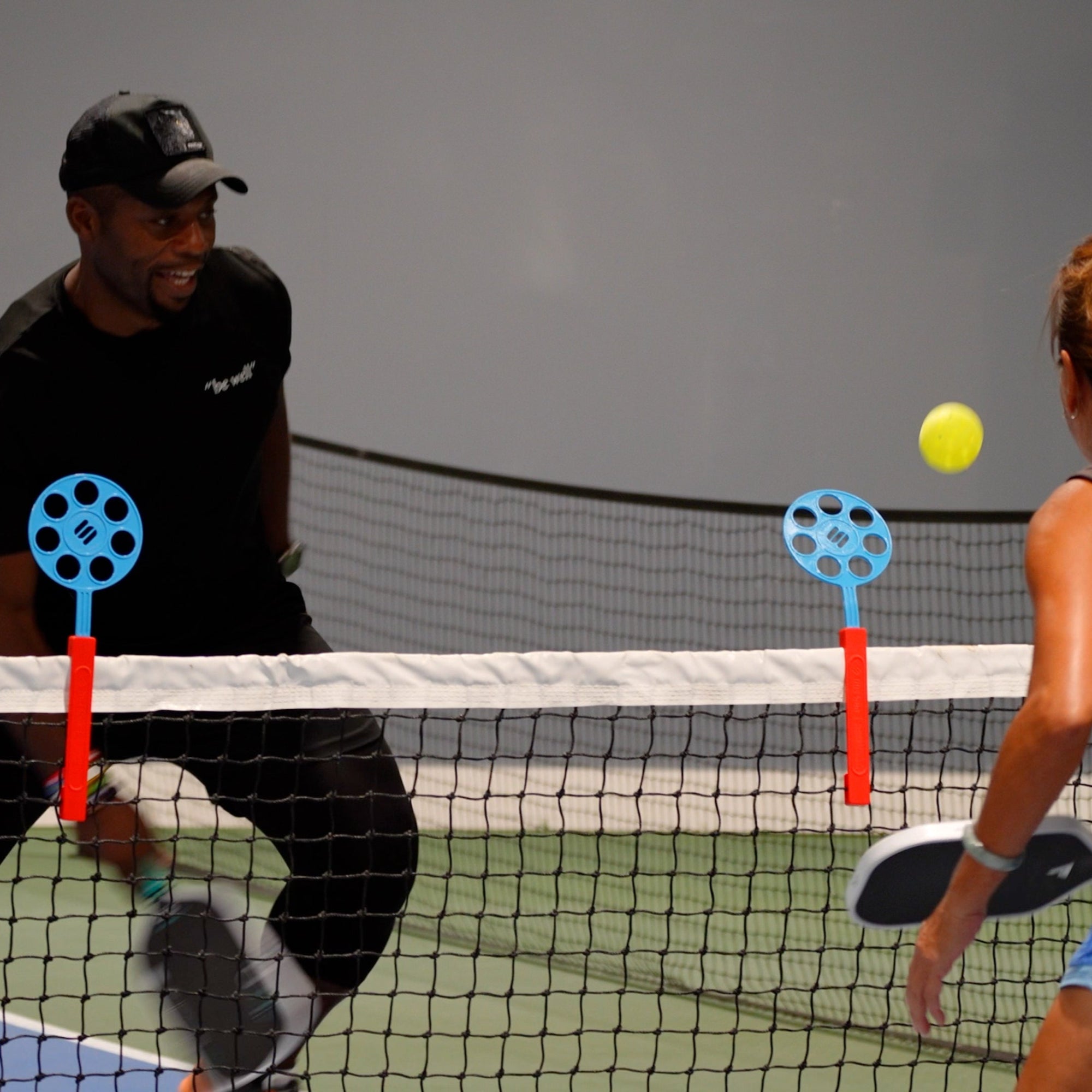 man and woman use pickleball training tool